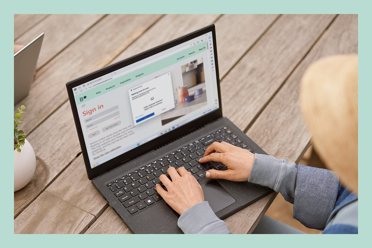En kvinna använder en laptop och använder den inbyggda säkerheten i Windows 11.